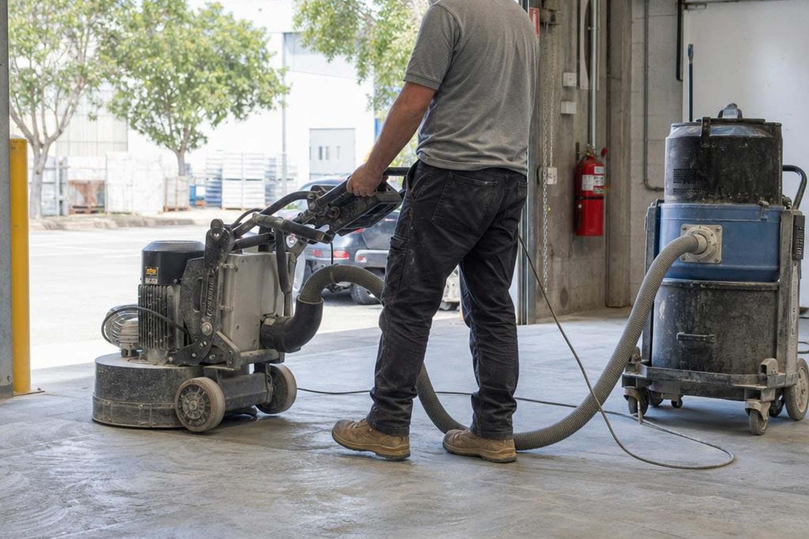 Commercial planetary grinder and dust extraction operating across a large Sydney concrete slab