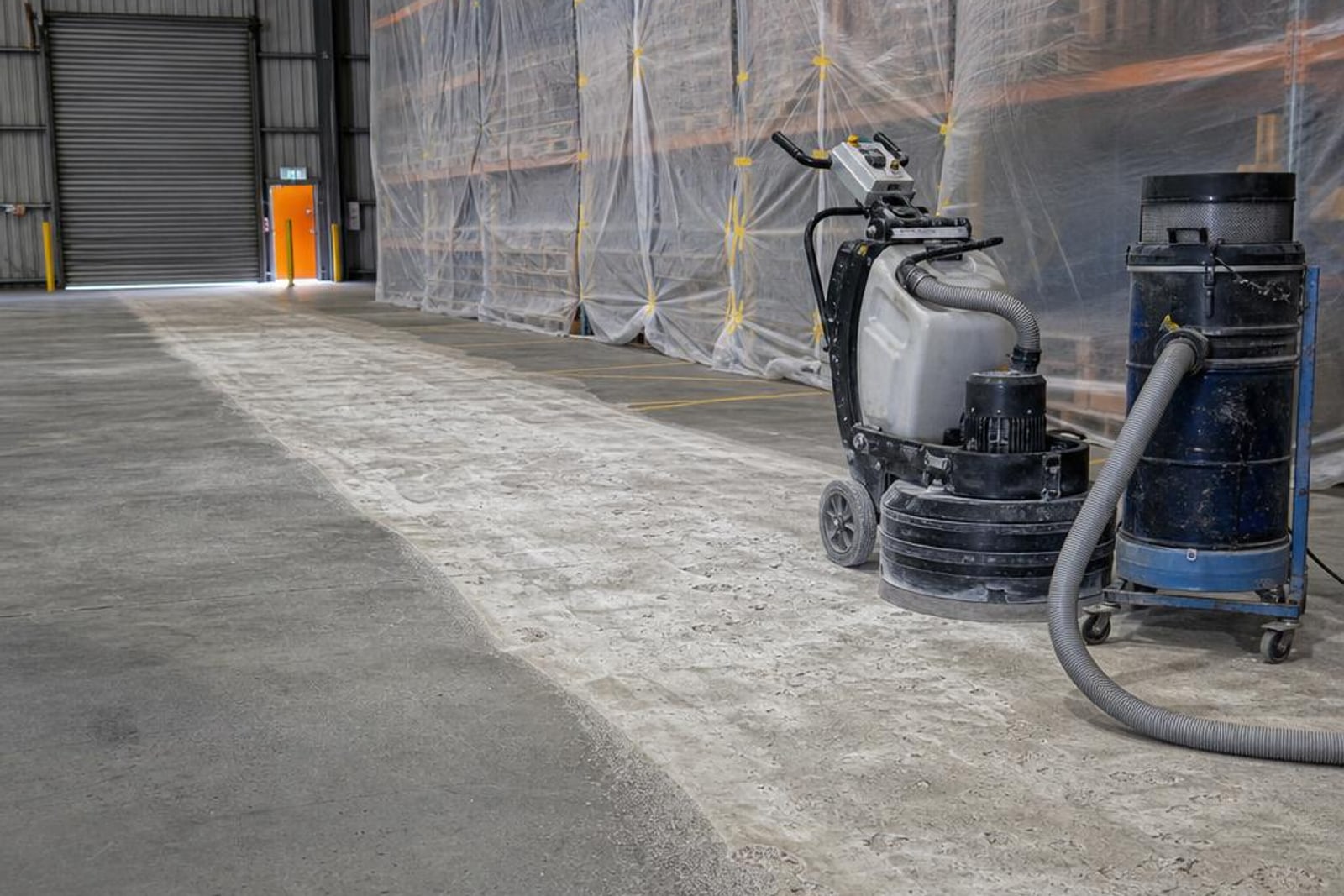 Warehouse floor preparation zone with grinder, vacuum and protected storage racking